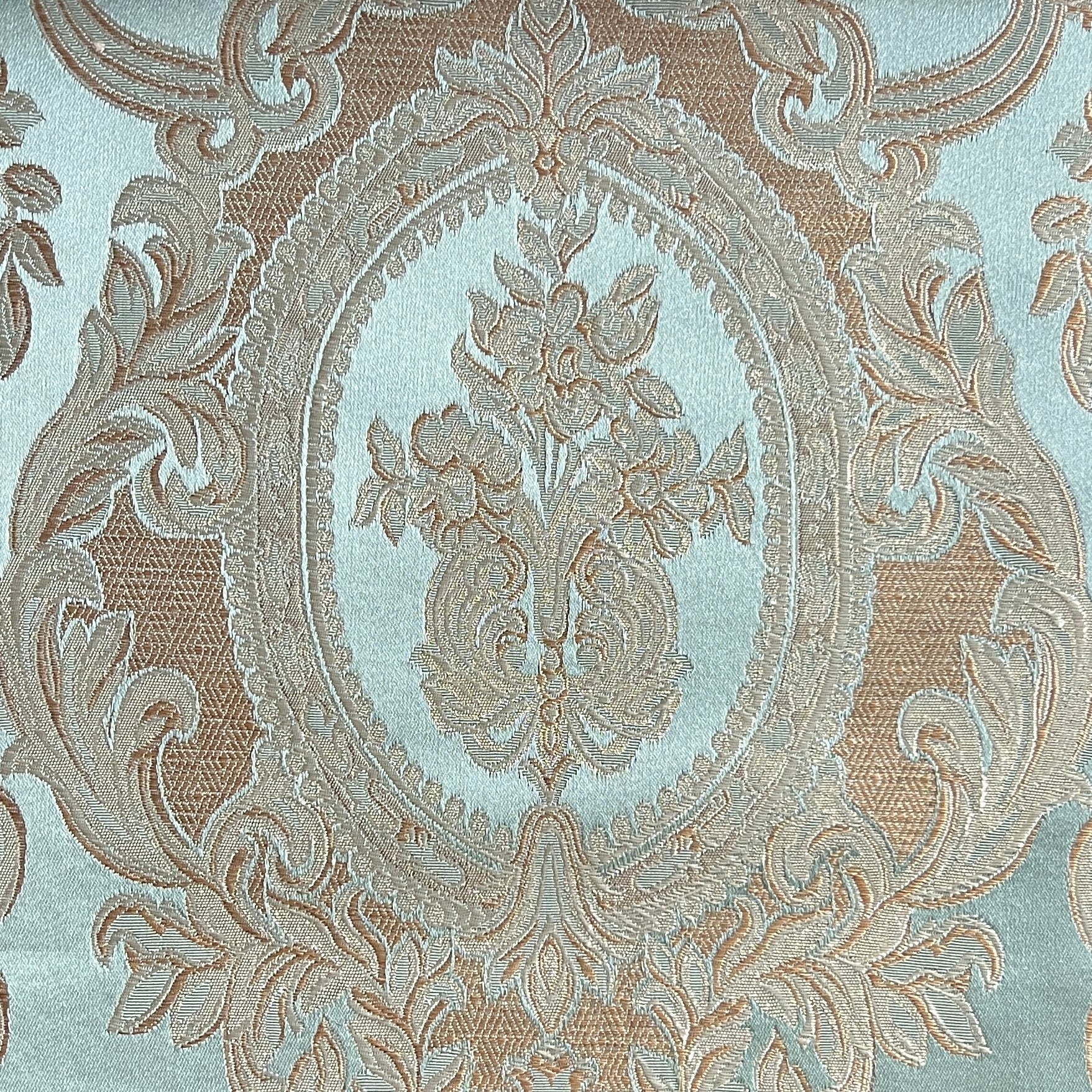 Close-up of damask ornate floral pattern on fabric with Pista color background