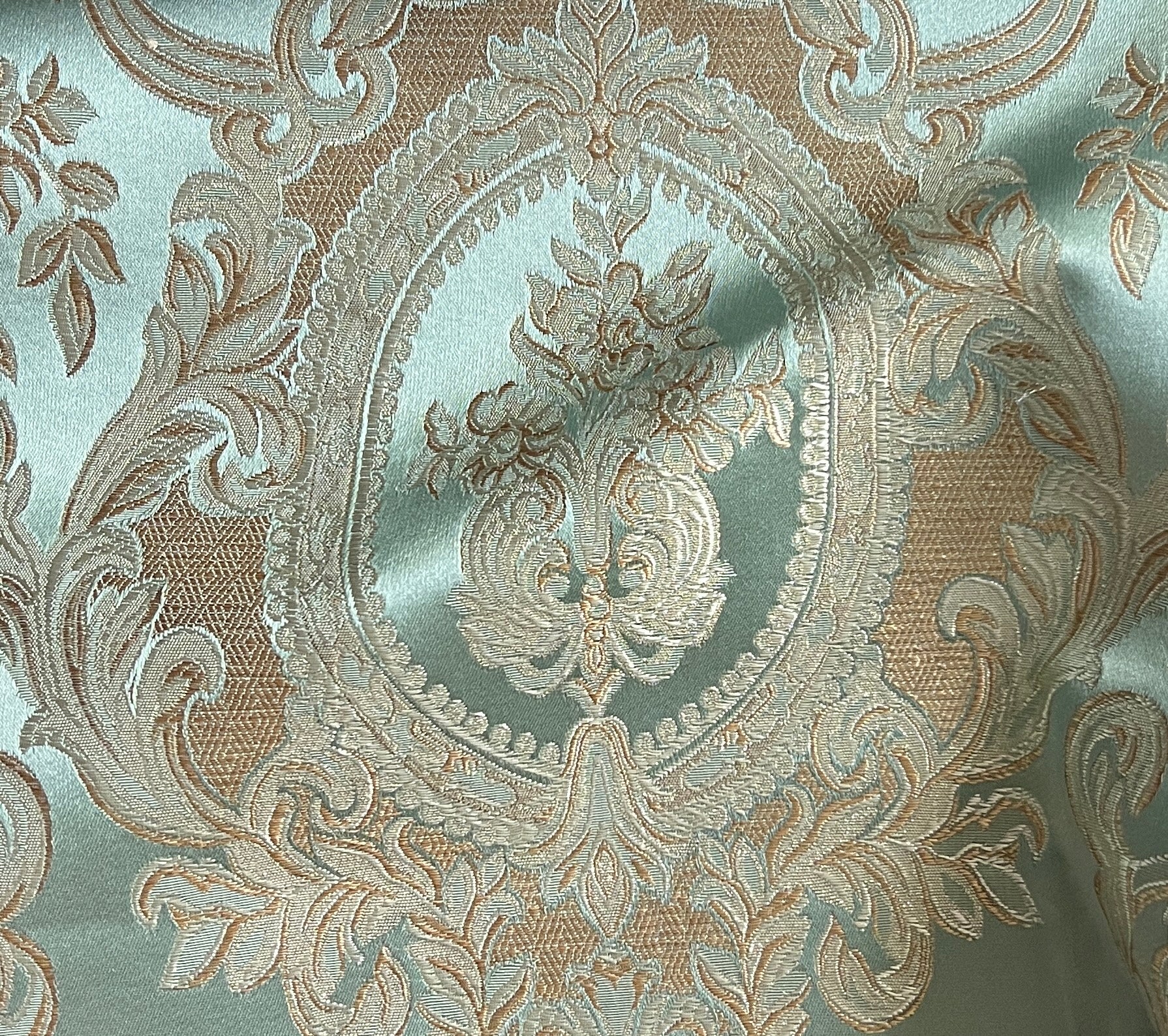 Close-up of damask ornate floral pattern on fabric with Pista color background