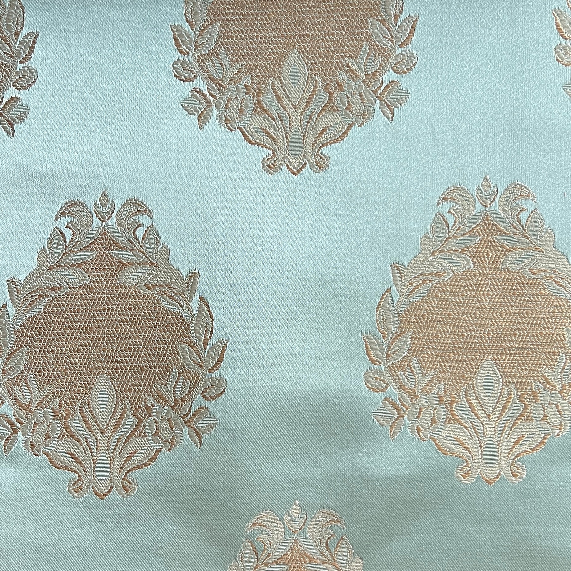 Decorative fabric pattern with intricate white designs on a Pista background