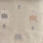 Decorative fabric with intricate patterns on a Pinkish background