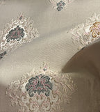 Decorative fabric with intricate patterns on a Pinkish background