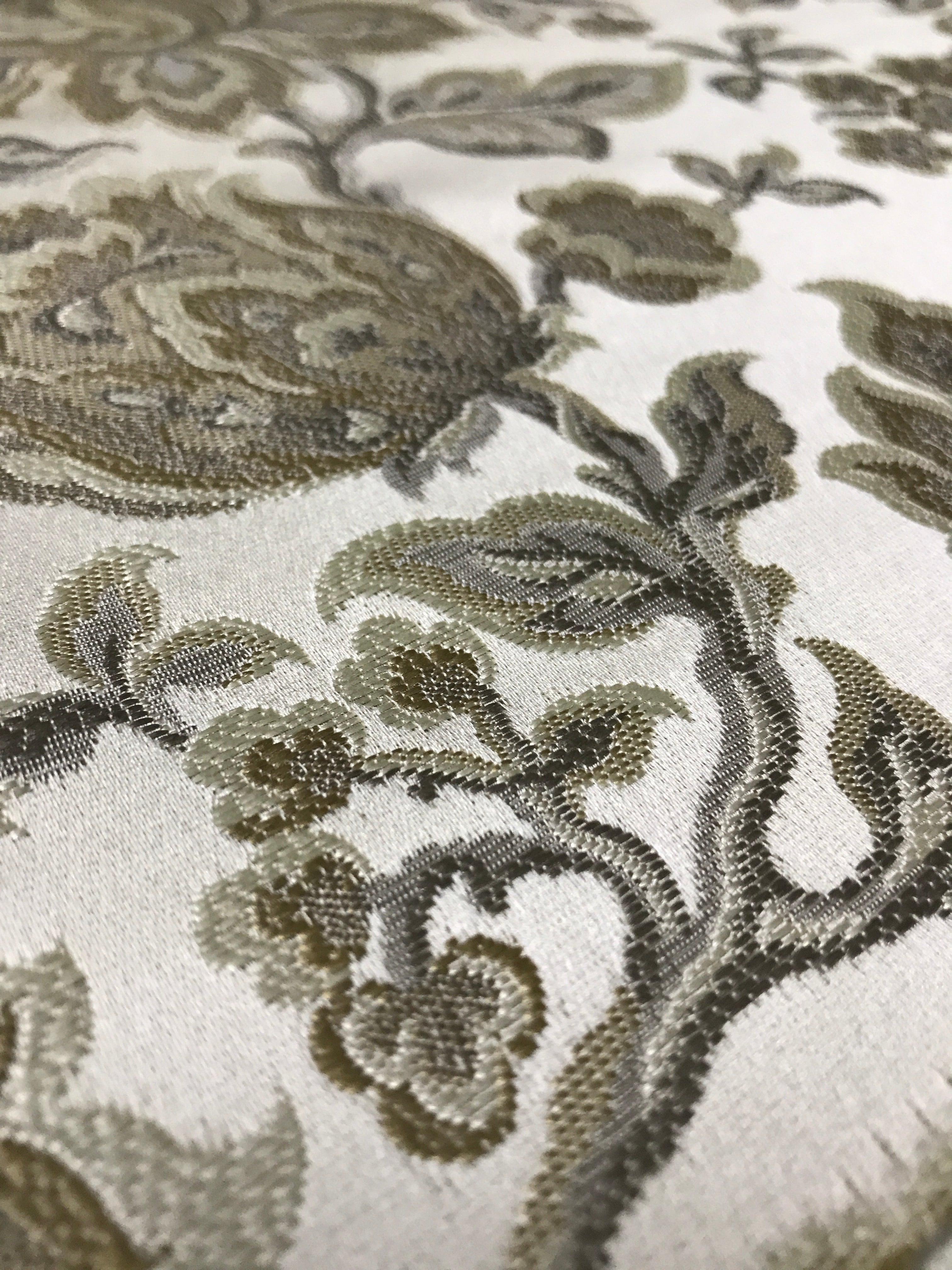 Gold floral jacquard fabric folded, texture close-up.