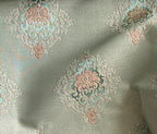 Decorative fabric with intricate patterns on a Pista background