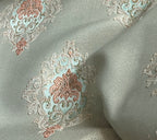 Decorative fabric with intricate patterns on a Pista background