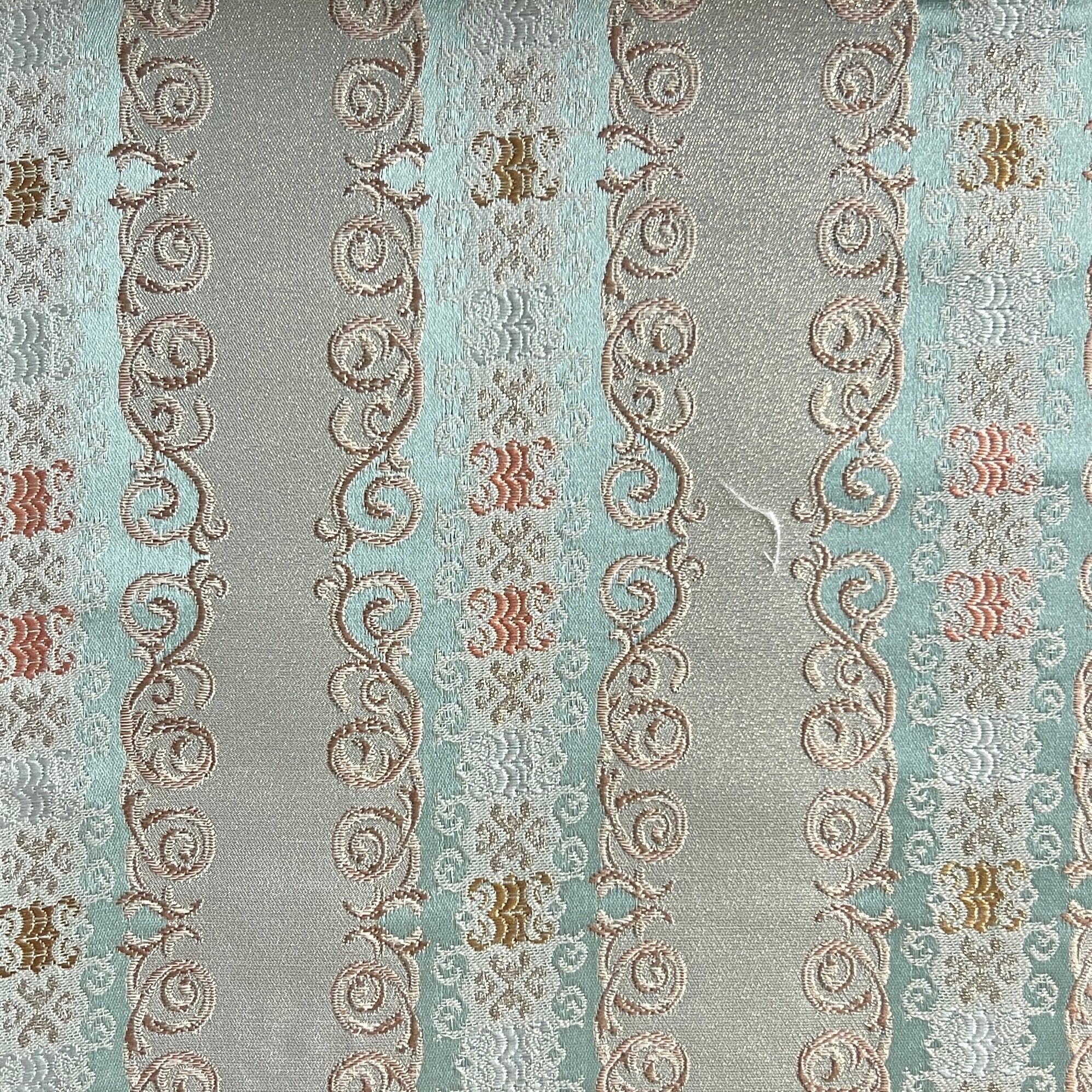 Decorative fabric pattern with intricate designs and color accents on a Pista  background