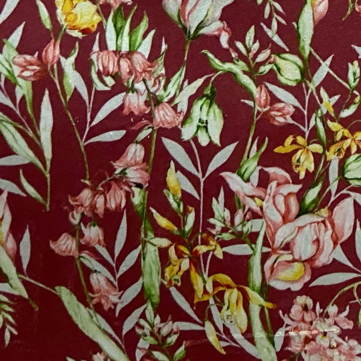 Floral pattern with green leaves and white flowers on Maroon background