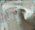Decorative fabric pattern with intricate designs and color accents on a Pista background