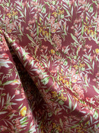 Floral pattern with green leaves and white flowers on Maroon background