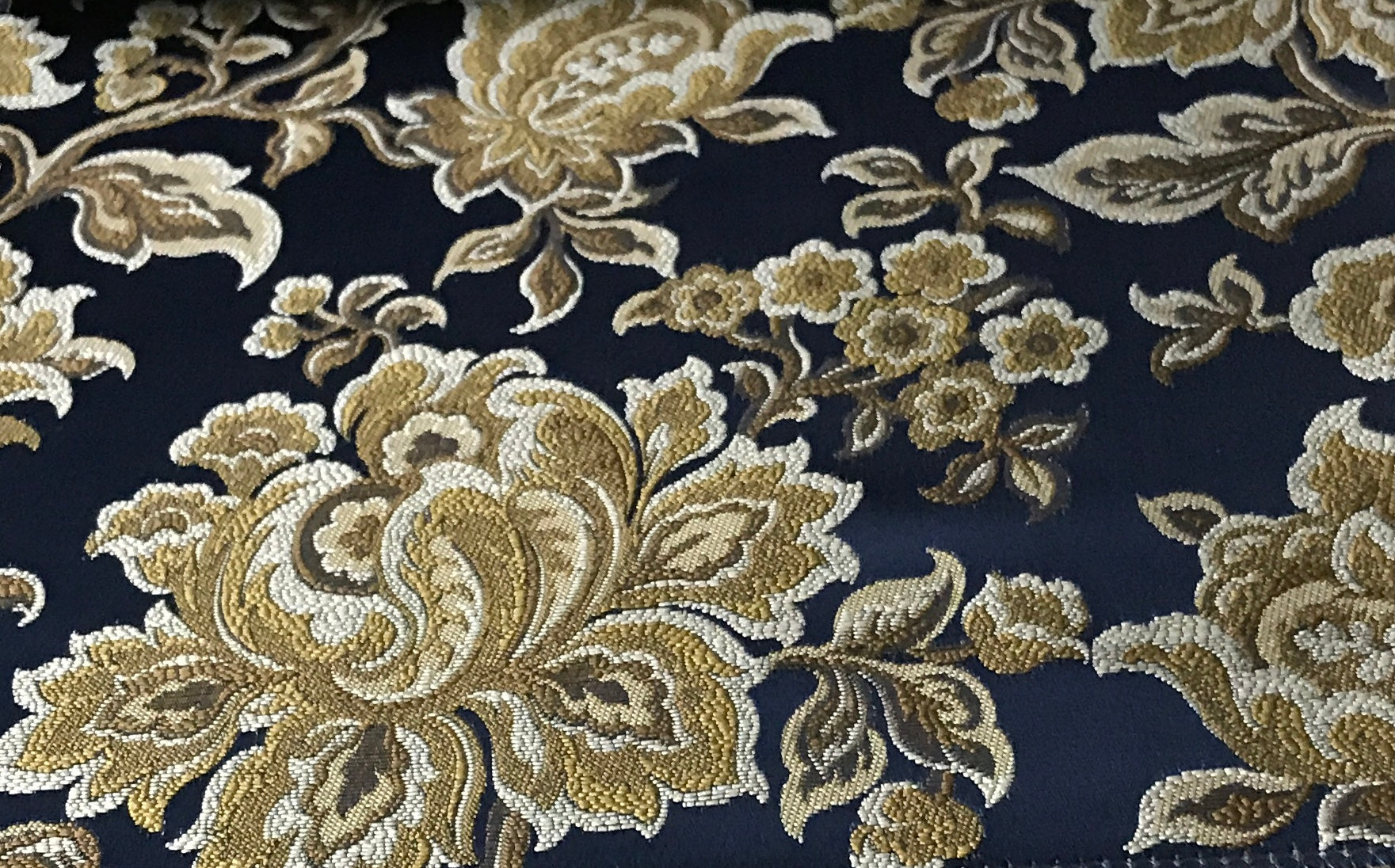 Navy floral jacquard fabric folded, texture close-up.