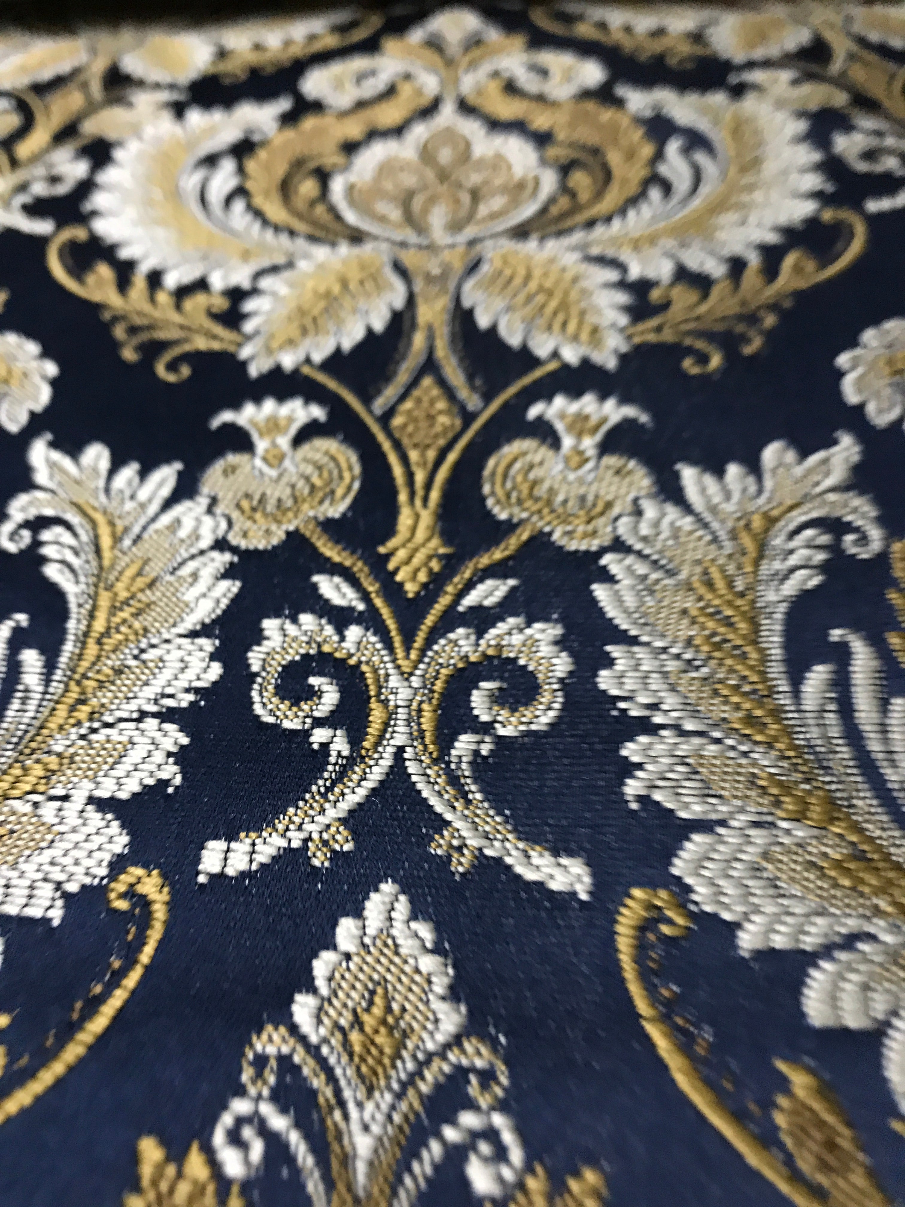 Navy damask fabric folded, texture and sheen close-up