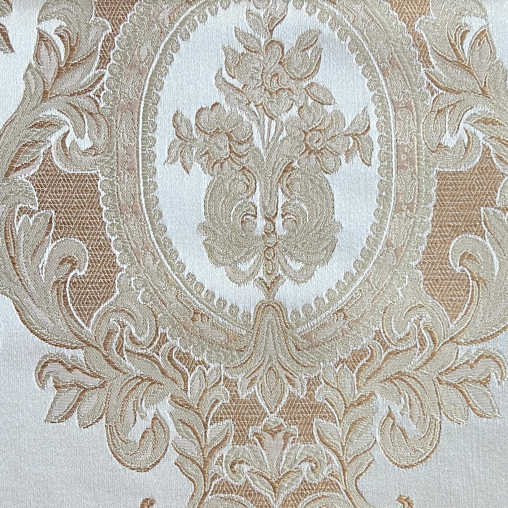 Close-up of damask ornate floral pattern on fabric with Cream color background