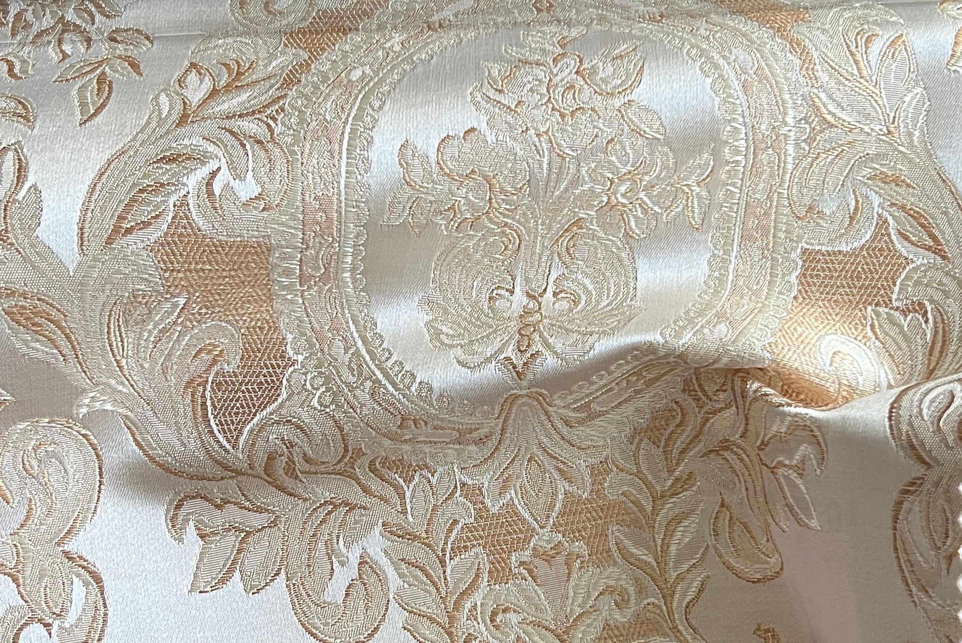 Close-up of damask ornate floral pattern on fabric with Cream color background