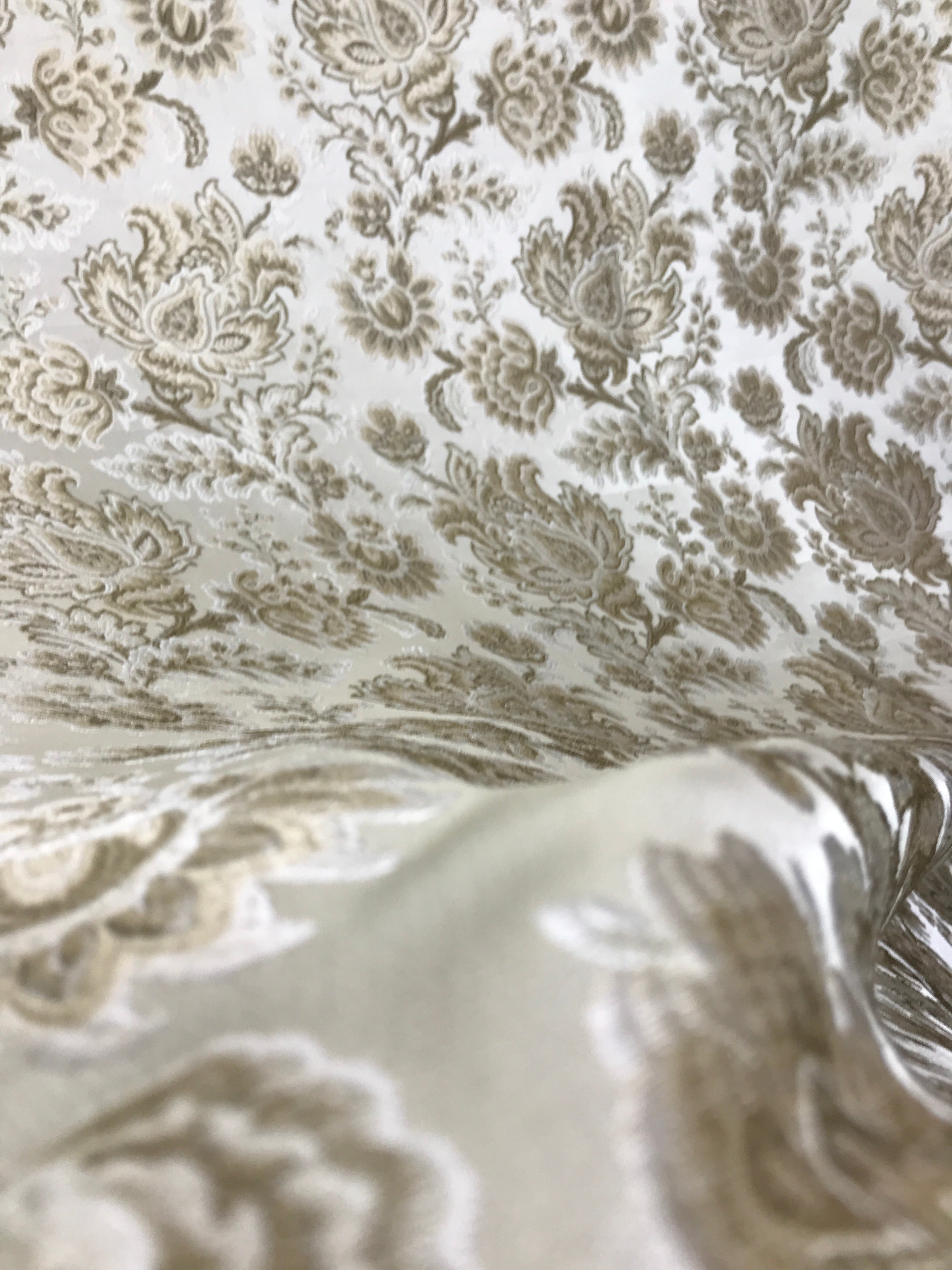Patterned fabric with floral design in beige on a light Cream background