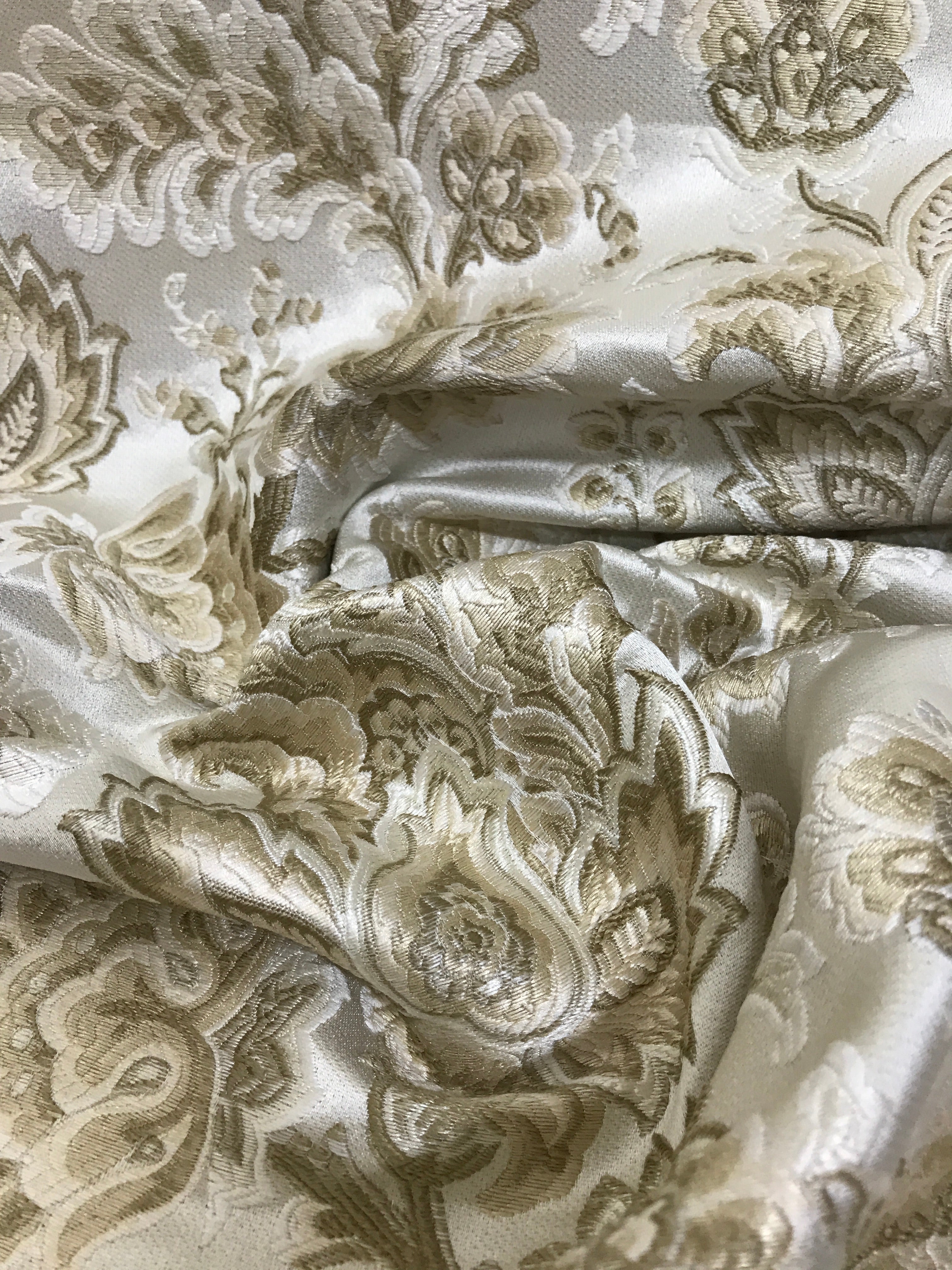 Patterned fabric with floral design in beige on a light Cream background