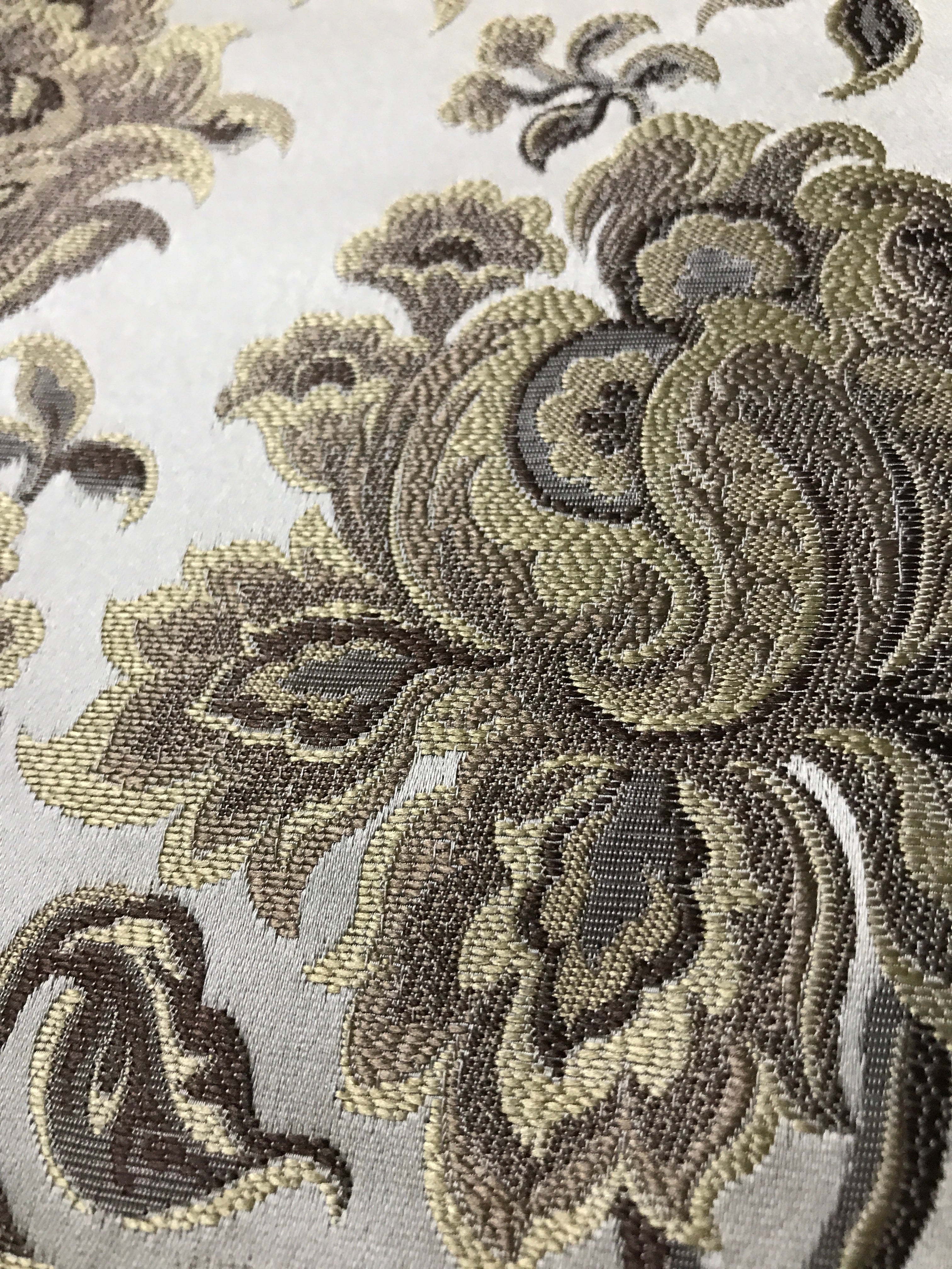 Taupe floral jacquard fabric folded, texture close-up.