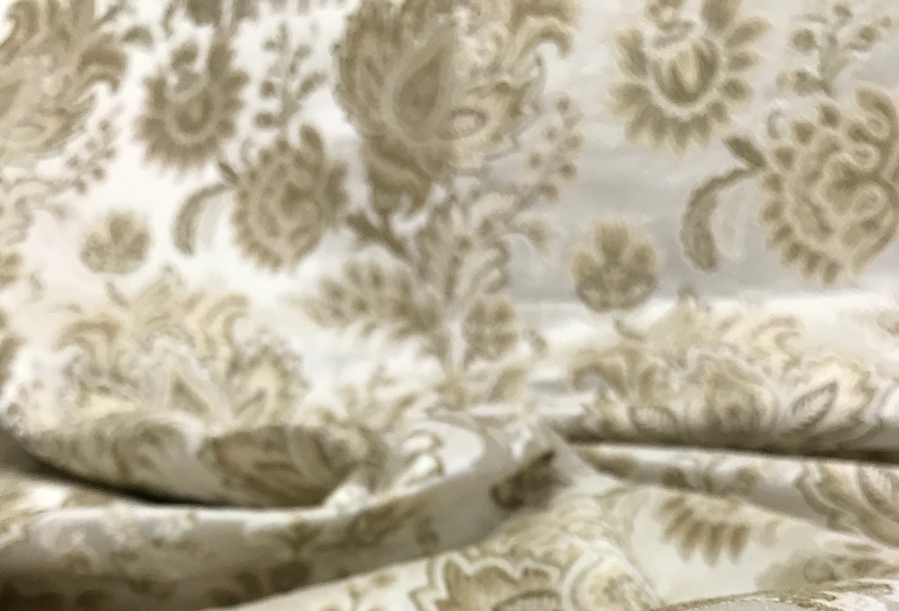 Patterned fabric with floral design in beige on a light Cream background