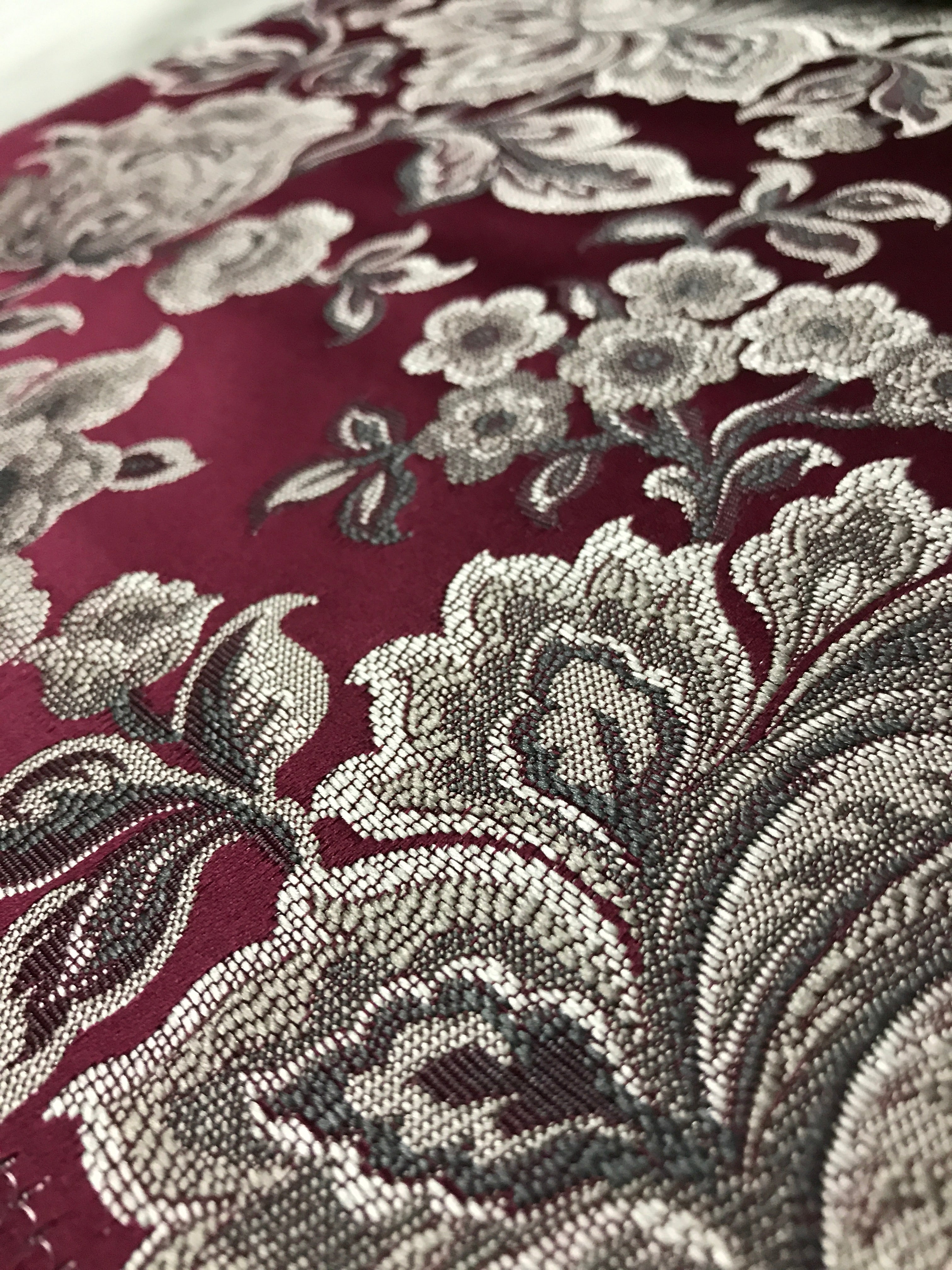 Maroon floral jacquard fabric swatch showing repeat pattern detail.