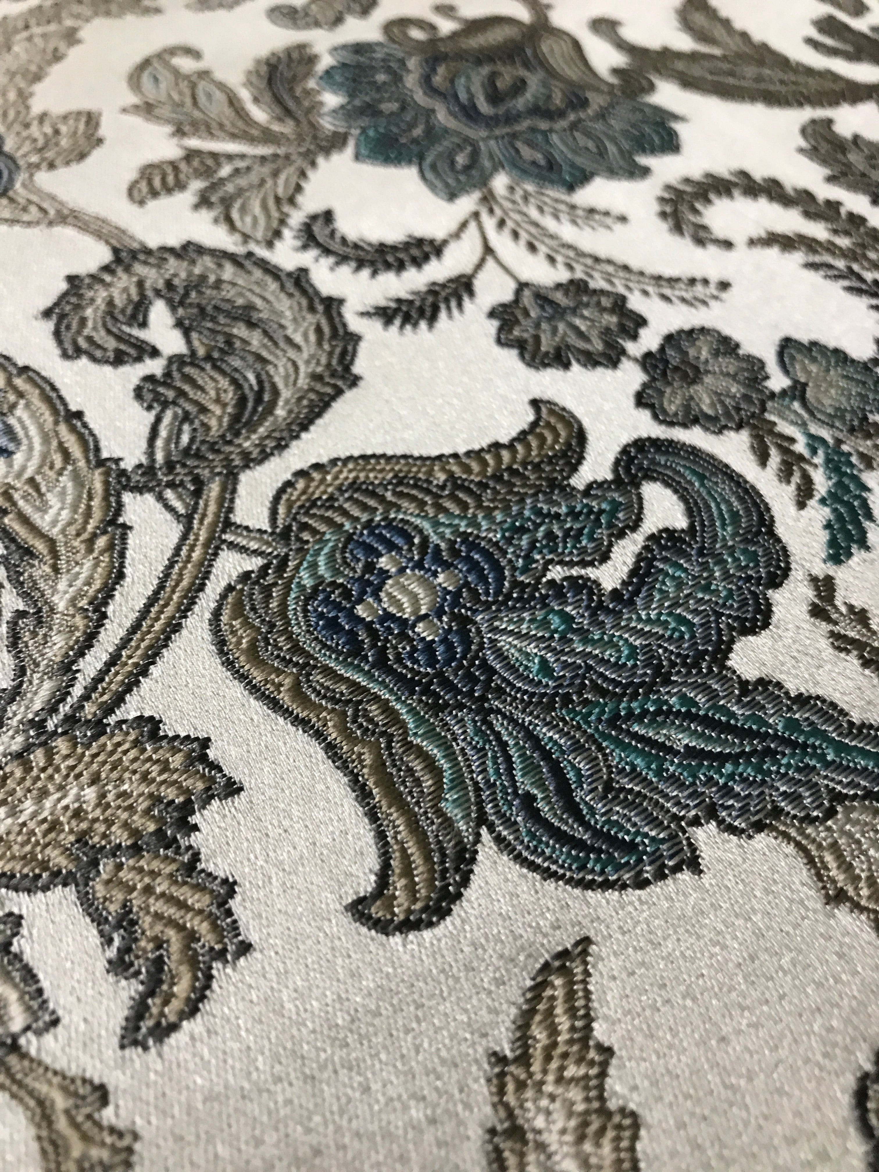 Close-up of intricate floral embroidery on fabric Teal Sage