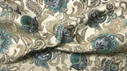 Close-up of decorative fabric with floral patterns in Teal Sage color on a beige background 
