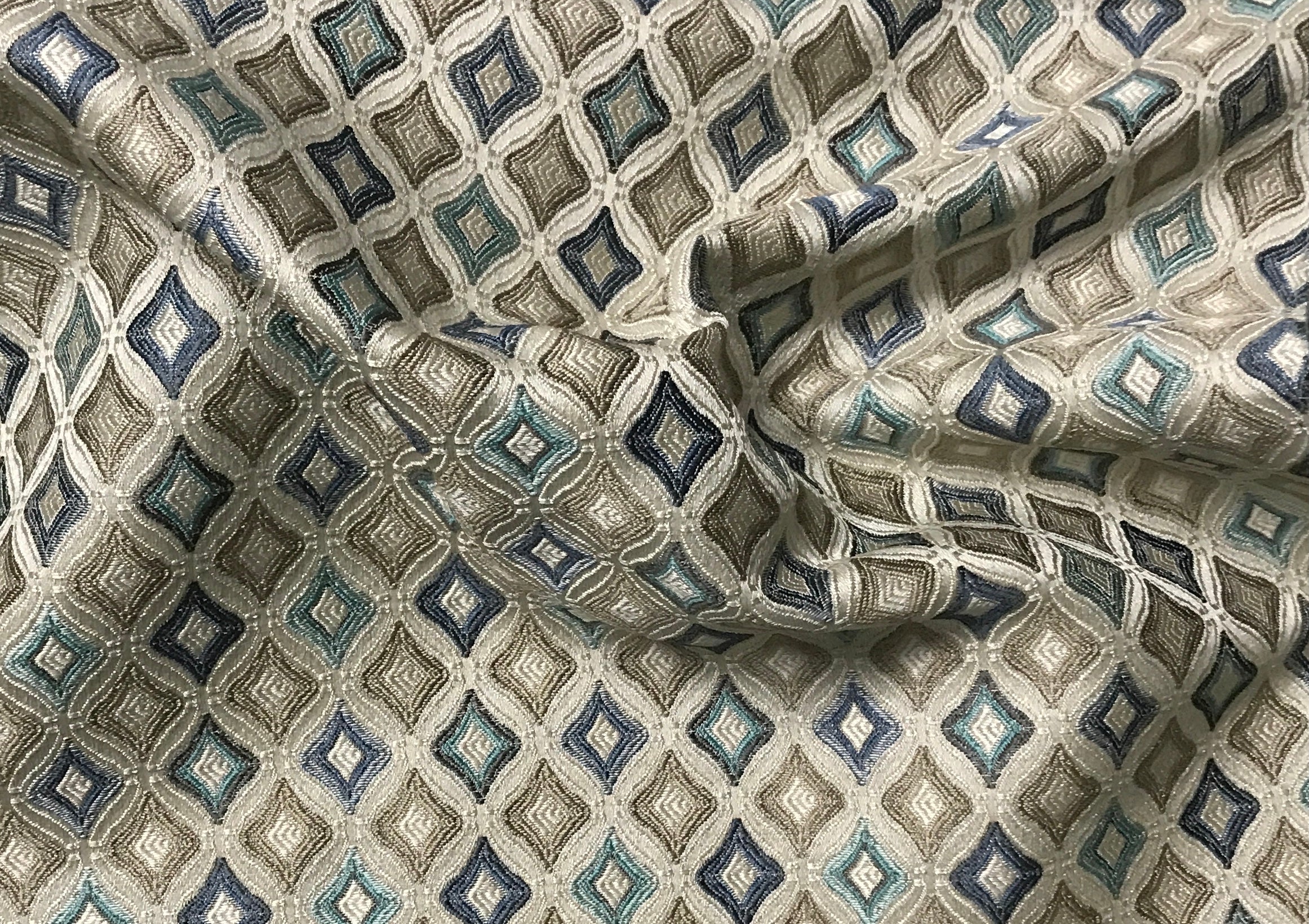 Patterned fabric with geometric design in shades of blue, beige, and gray. Teal Sage