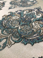 Close-up of intricate paisley pattern on fabric with teal, gray, and beige colors. Teal Sage