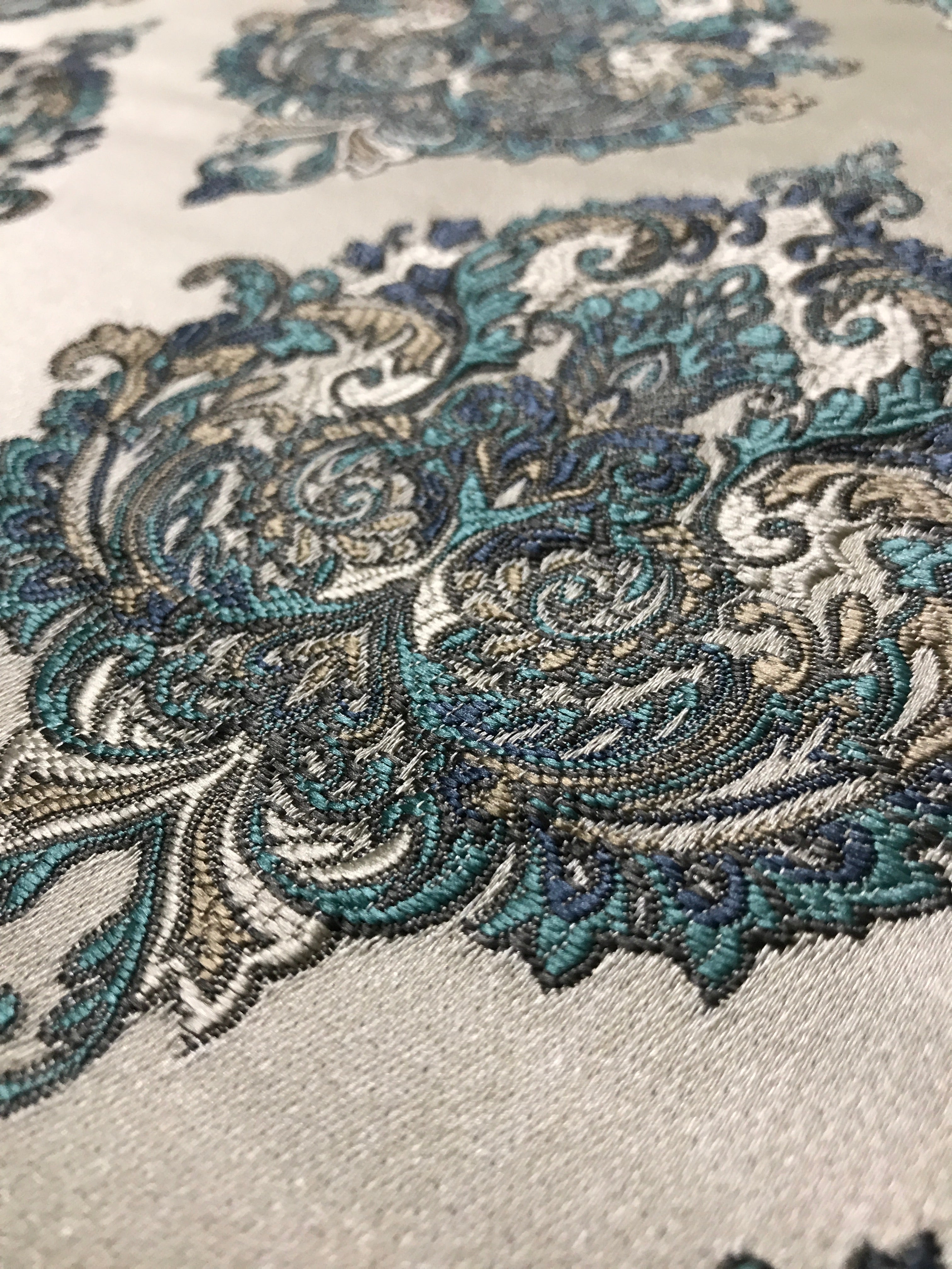 Close-up of intricate paisley pattern on fabric with teal, gray, and beige colors. Teal Sage