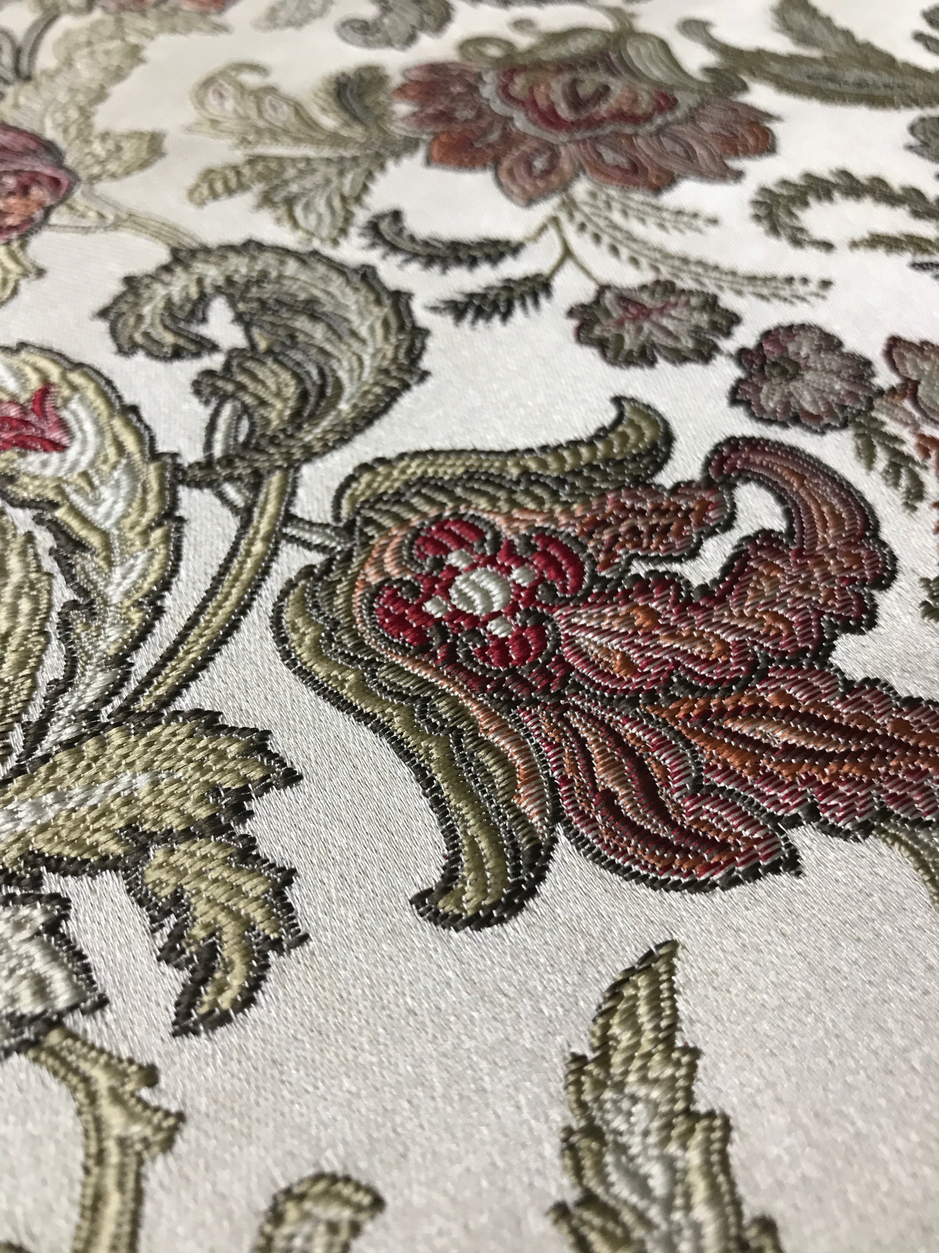 Close-up of intricate floral embroidery on fabric Sage Rose