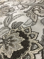 Close-up of intricate black floral embroidery on a fabric background Stone Age
