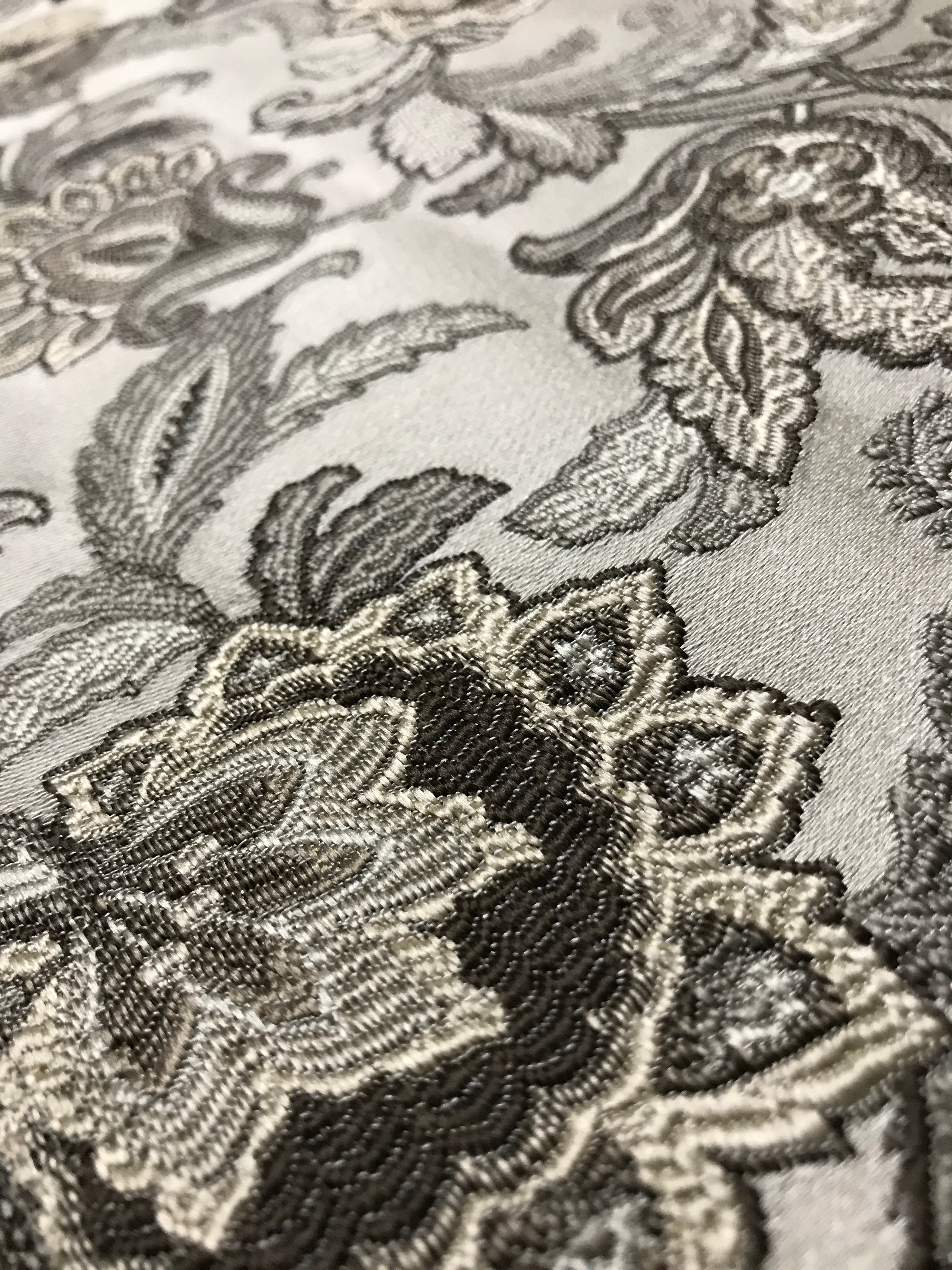 Close-up of intricate black floral embroidery on a fabric background Stone Age
