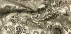Close-up of decorative fabric with intricate Stone Age floral pattern on beige background