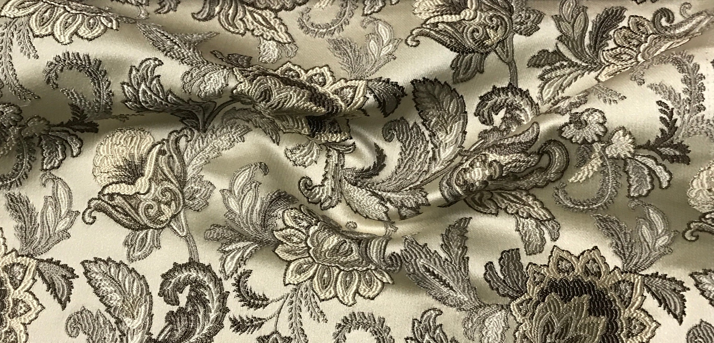 Close-up of decorative fabric with intricate Stone Age floral pattern on beige background