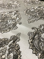 Close-up of intricate black paisley pattern on a light fabric background Stone Age