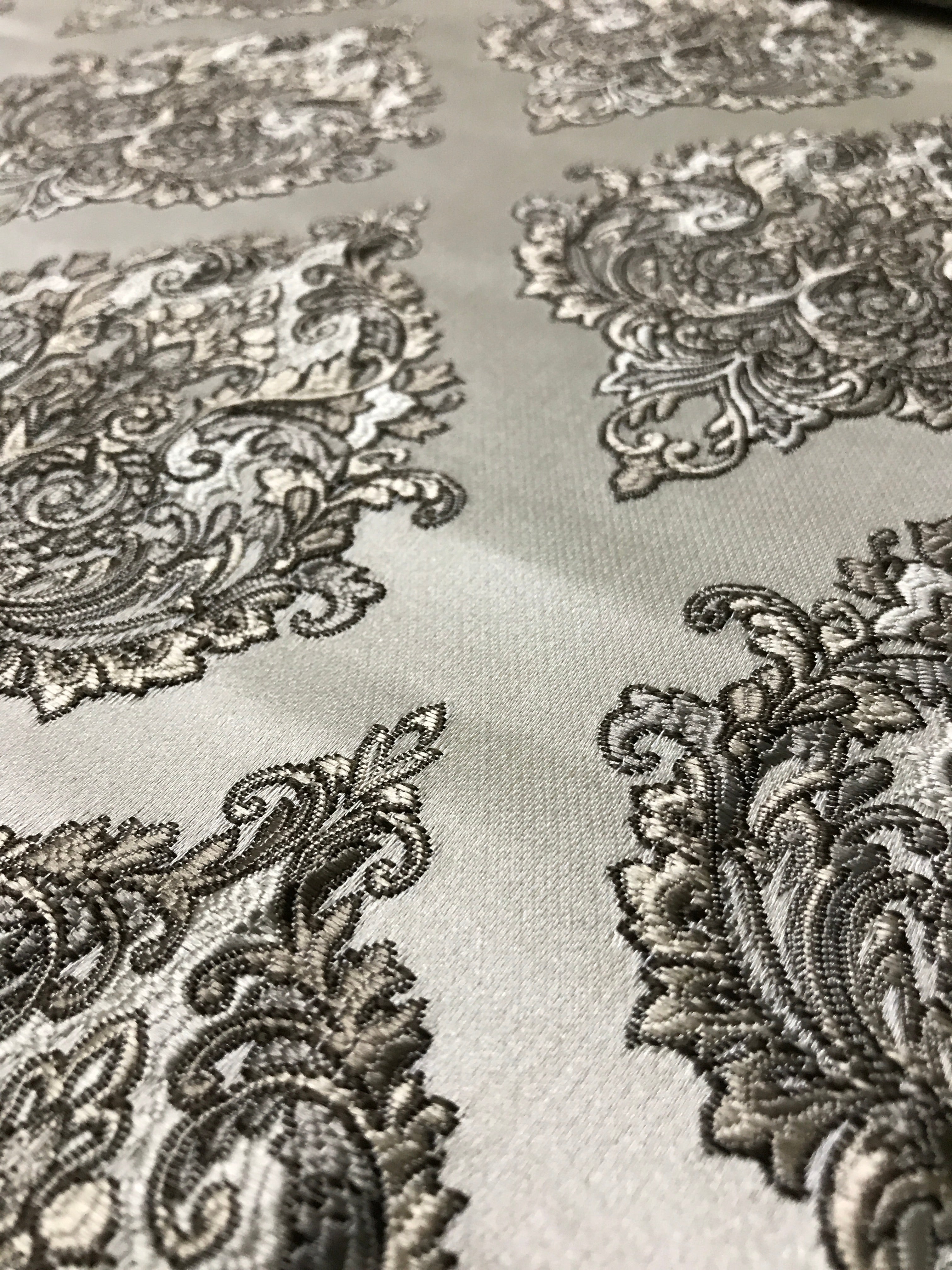 Close-up of intricate black paisley pattern on a light fabric background Stone Age