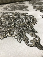 Close-up of intricate lace detailing on a fabric surface Stone Age