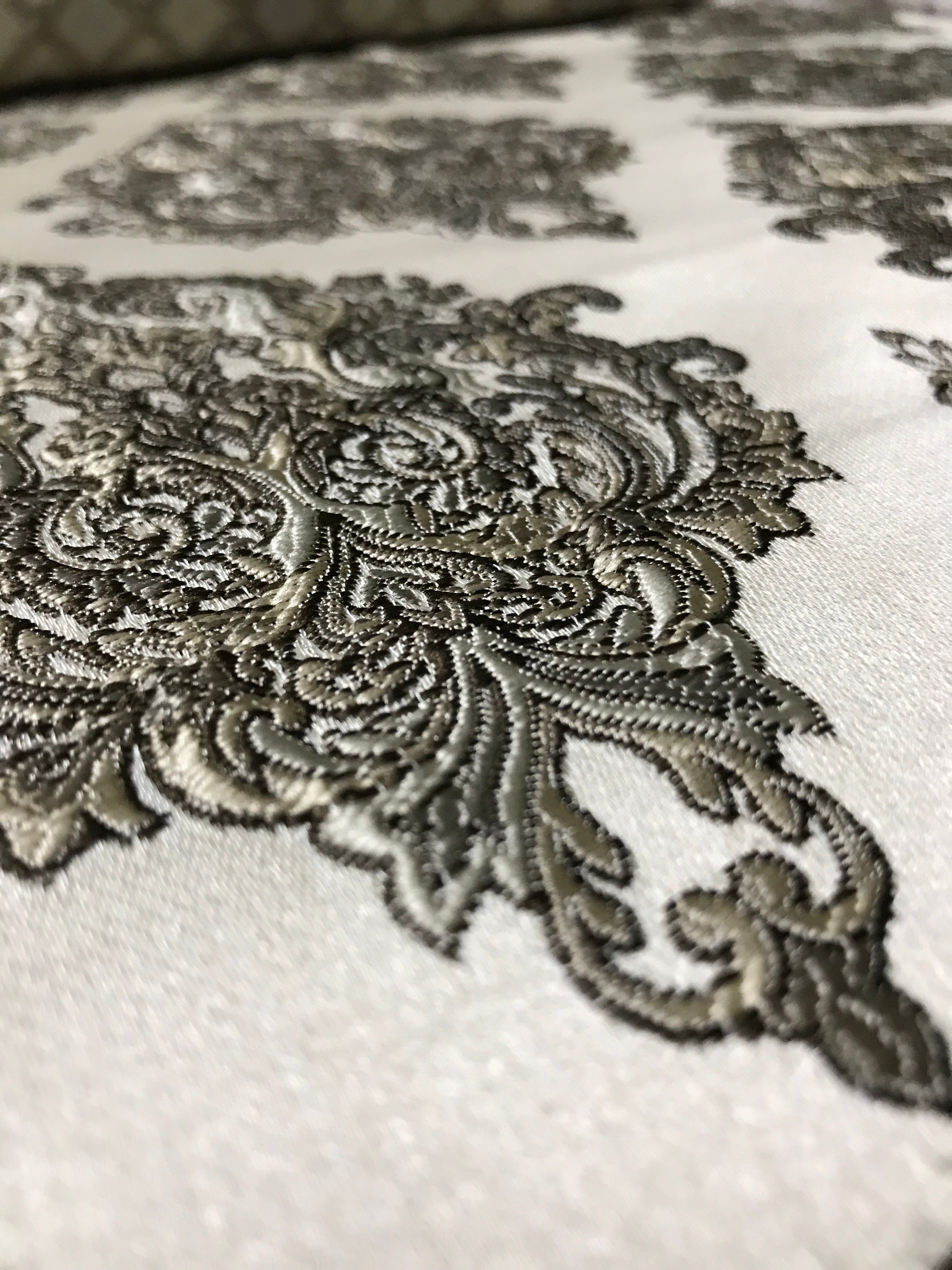 Close-up of intricate lace detailing on a fabric surface Stone Age