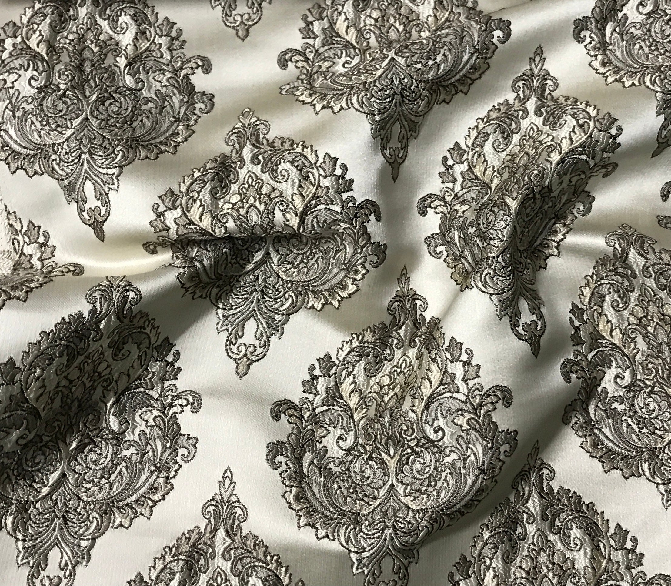 Decorative black paisley pattern on a white fabric background Stone Age