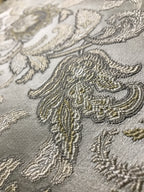 Close-up of embroidered fabric with floral patterns on a gray background Olive Sage