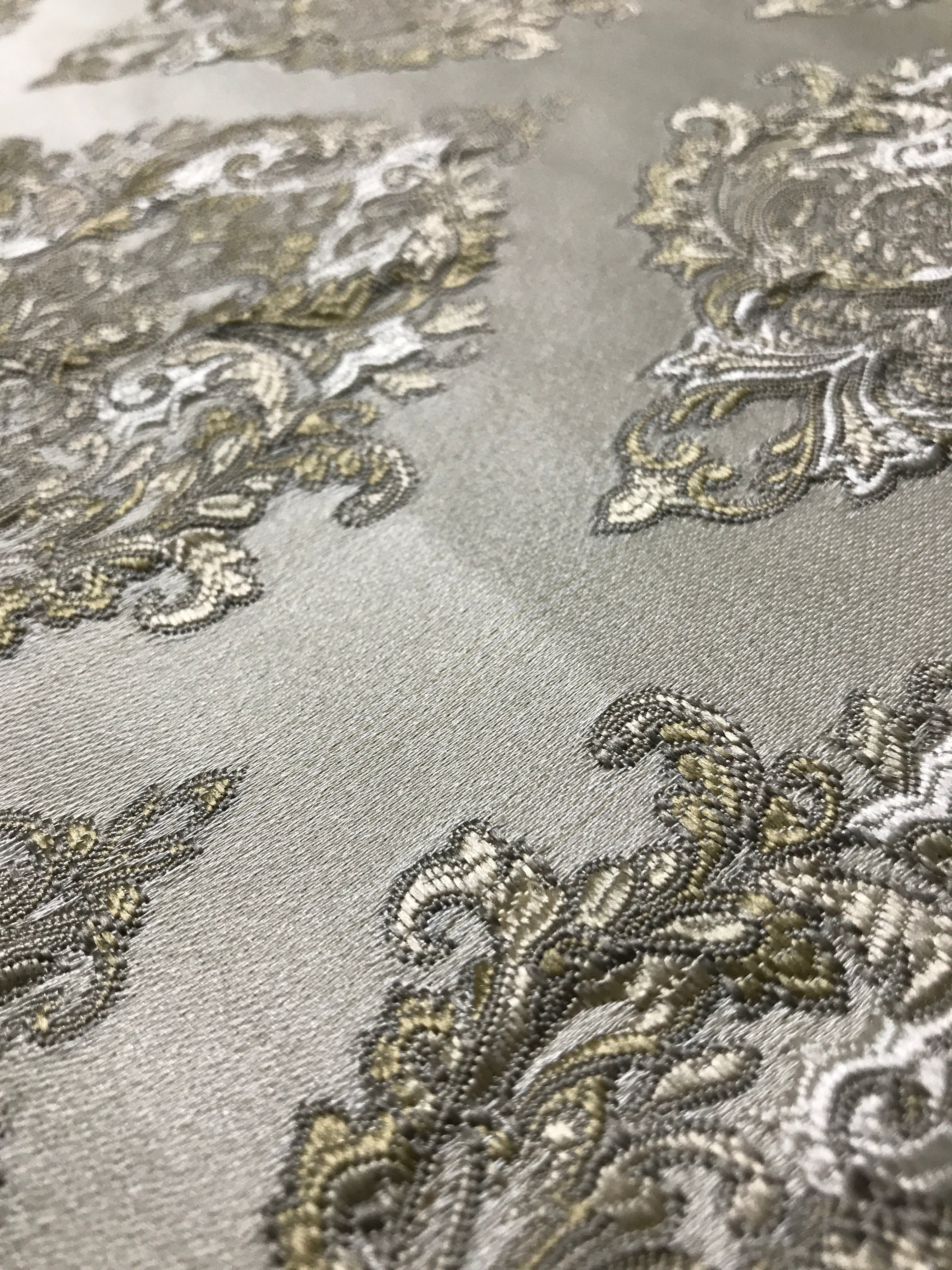 Close-up of decorative fabric with intricate patterns on a gray background Olive Sage