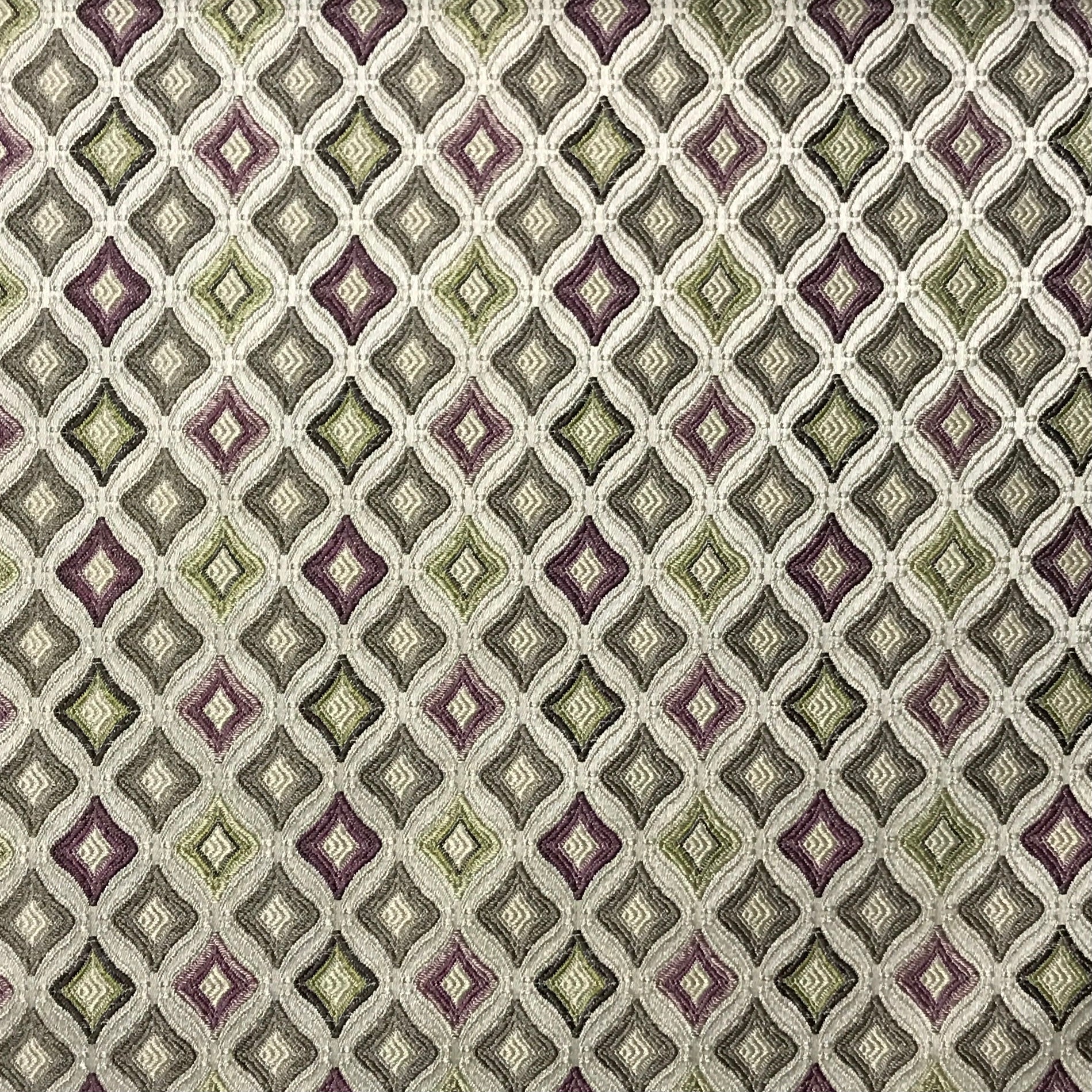 Patterned fabric with a geometric diamond design in green, purple, and beige Heritage Sage