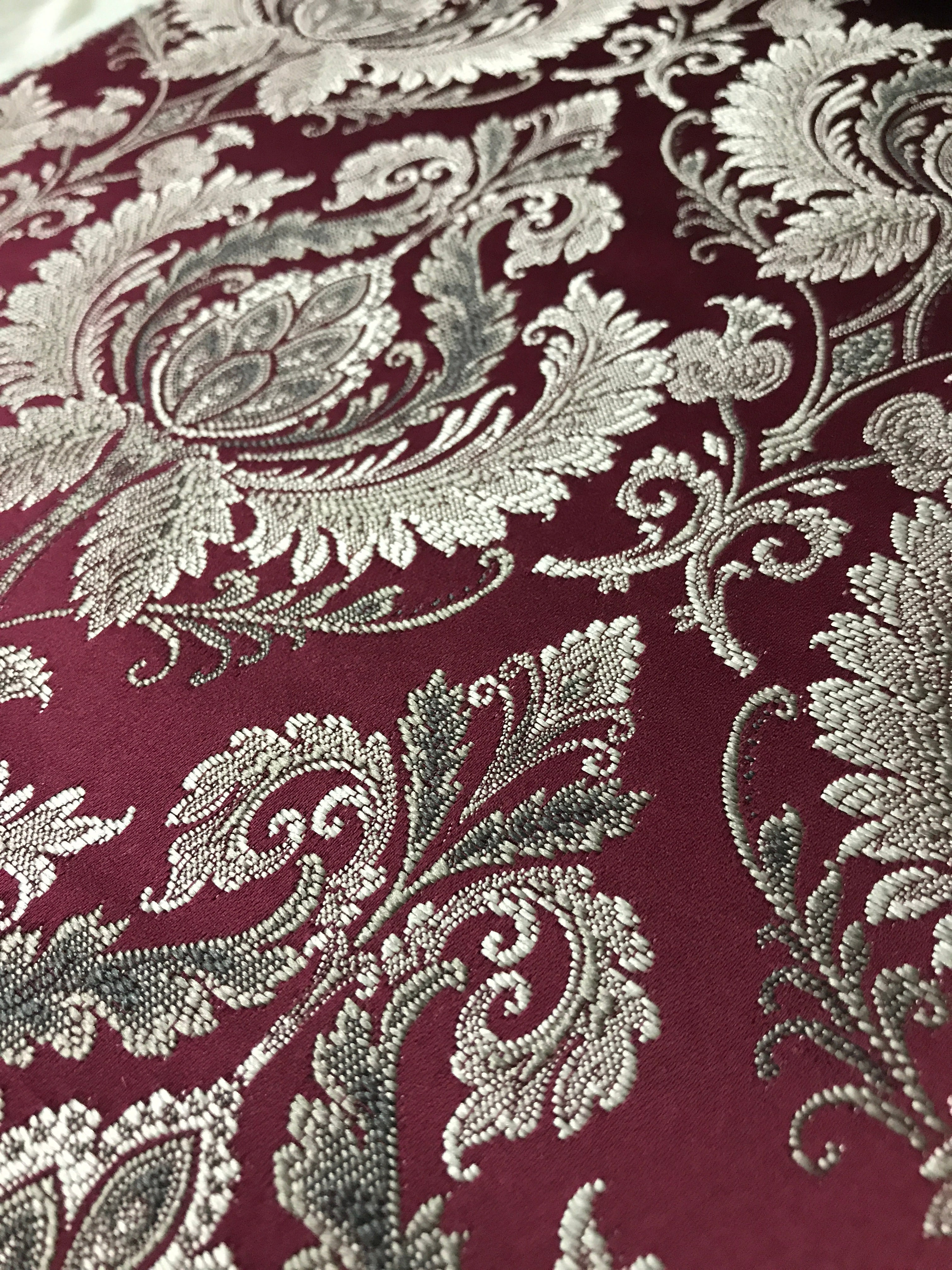 Maroon damask fabric swatch showing repeat pattern detail