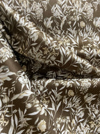Floral pattern with green leaves and white flowers on Umber colored background