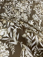 Floral pattern with green leaves and white flowers on Umber colored background