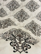 Decorative fabric pattern with Brown designs on a taupe background
