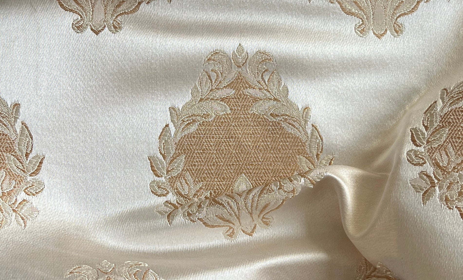 Decorative fabric with intricate floral gold patterns on a Cream background