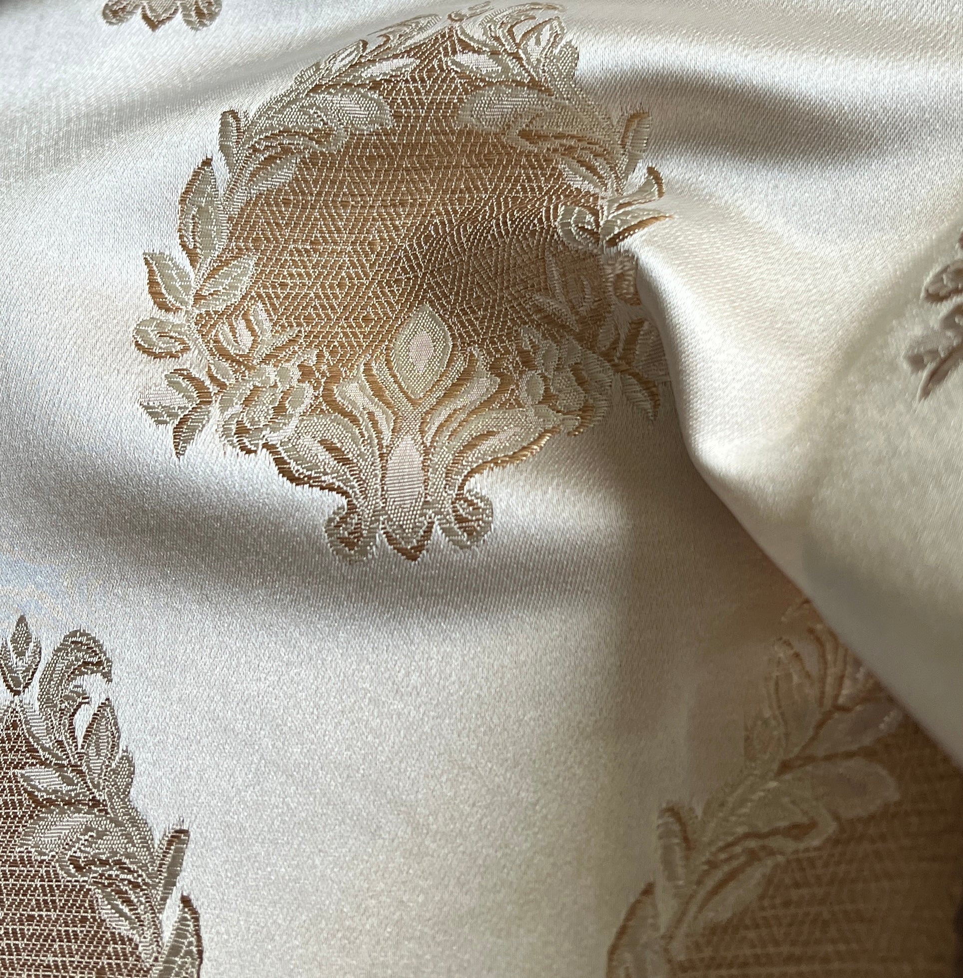 Decorative fabric with intricate floral gold patterns on a Cream background