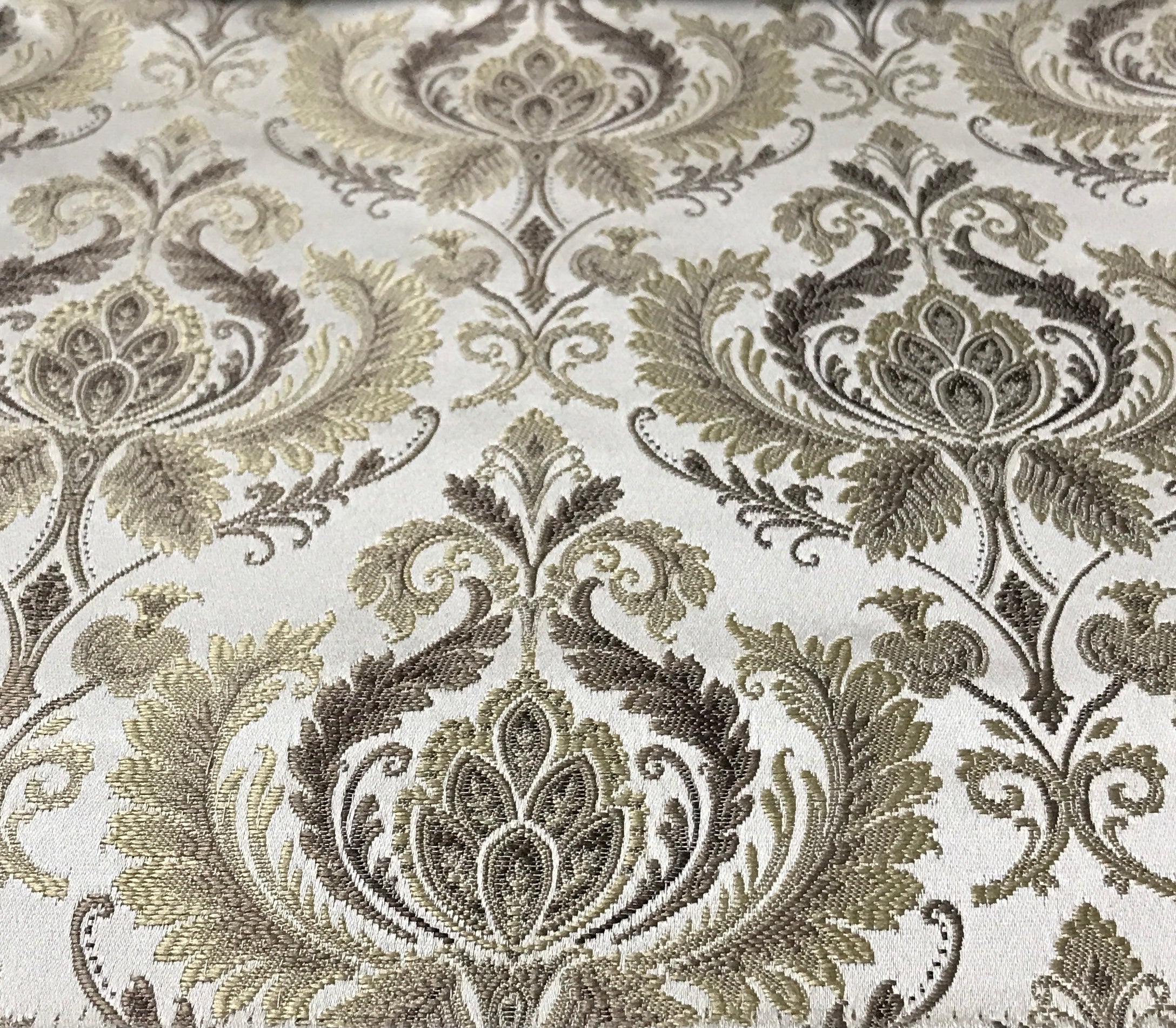 Taupe damask fabric folded, texture and sheen close-up