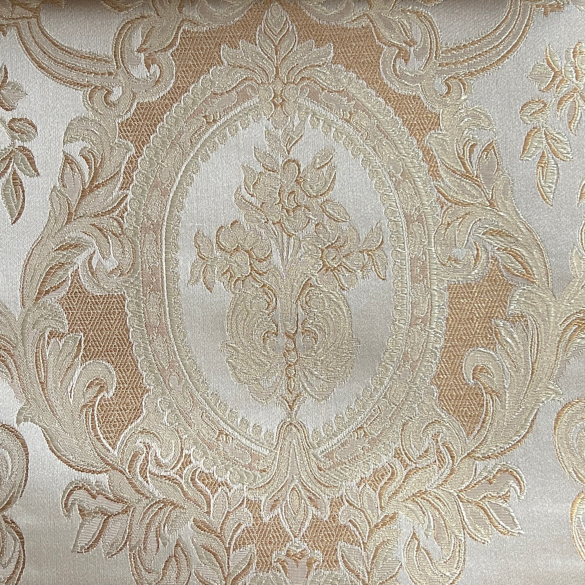 Close-up of damask ornate floral pattern on fabric with Beige color background