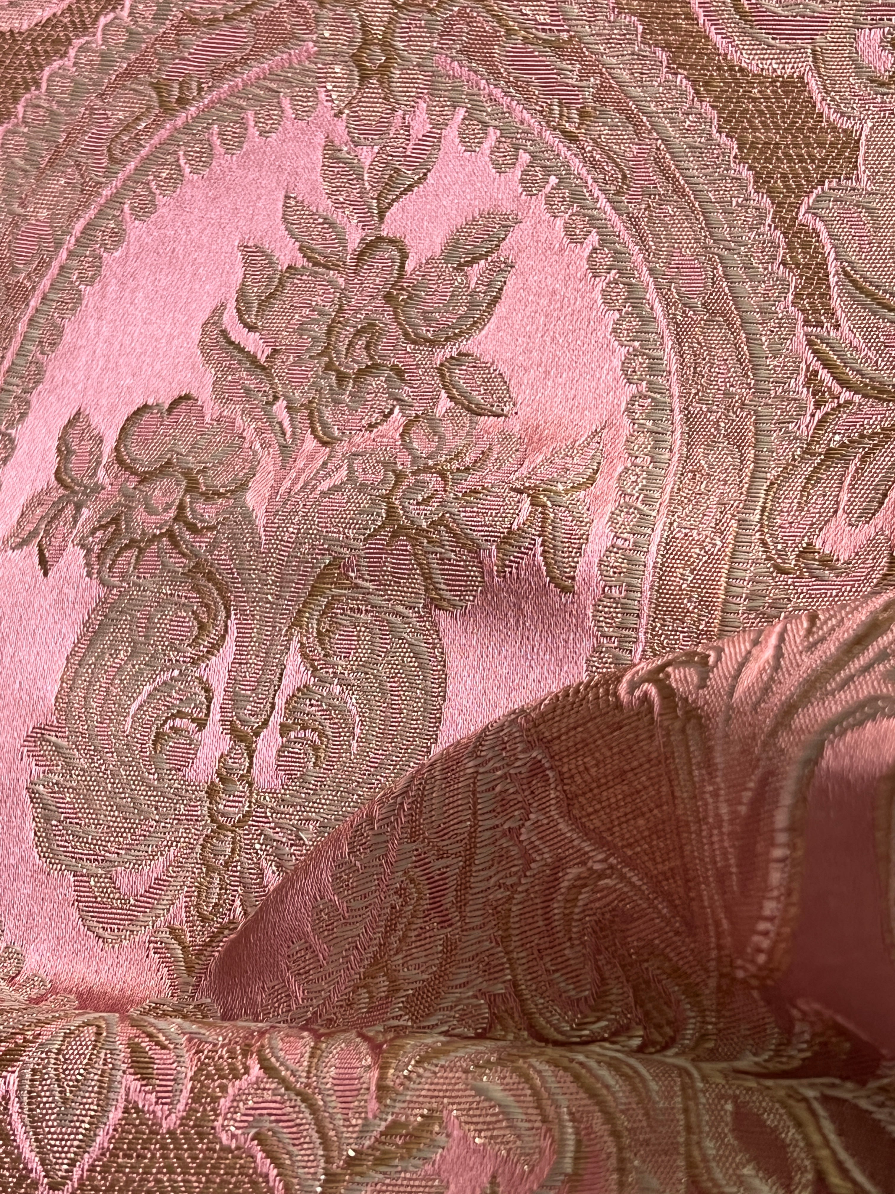 Close-up of damask ornate floral pattern on fabric with Rosewood color background