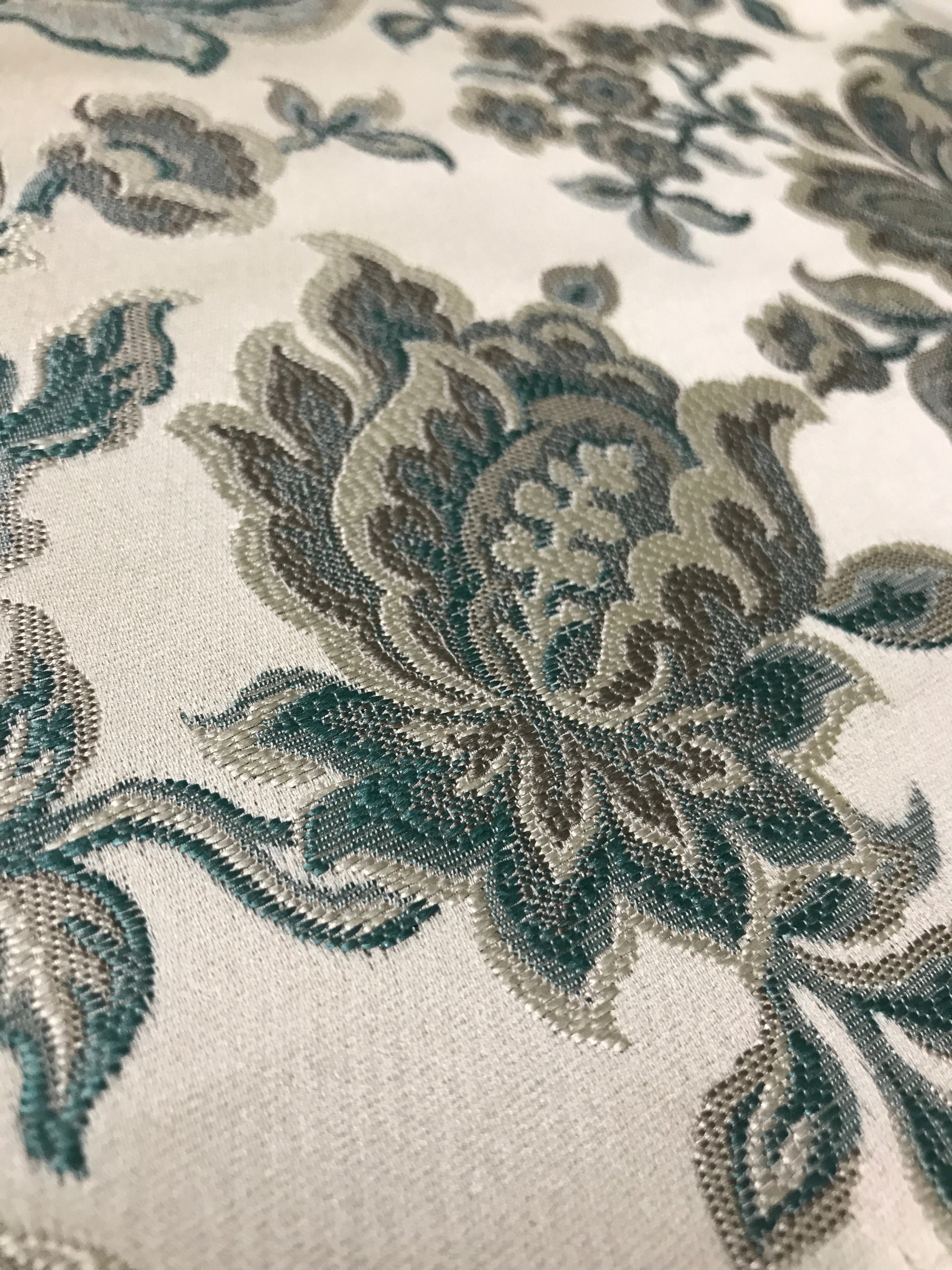 Sapphire blue floral jacquard fabric folded, texture close-up.