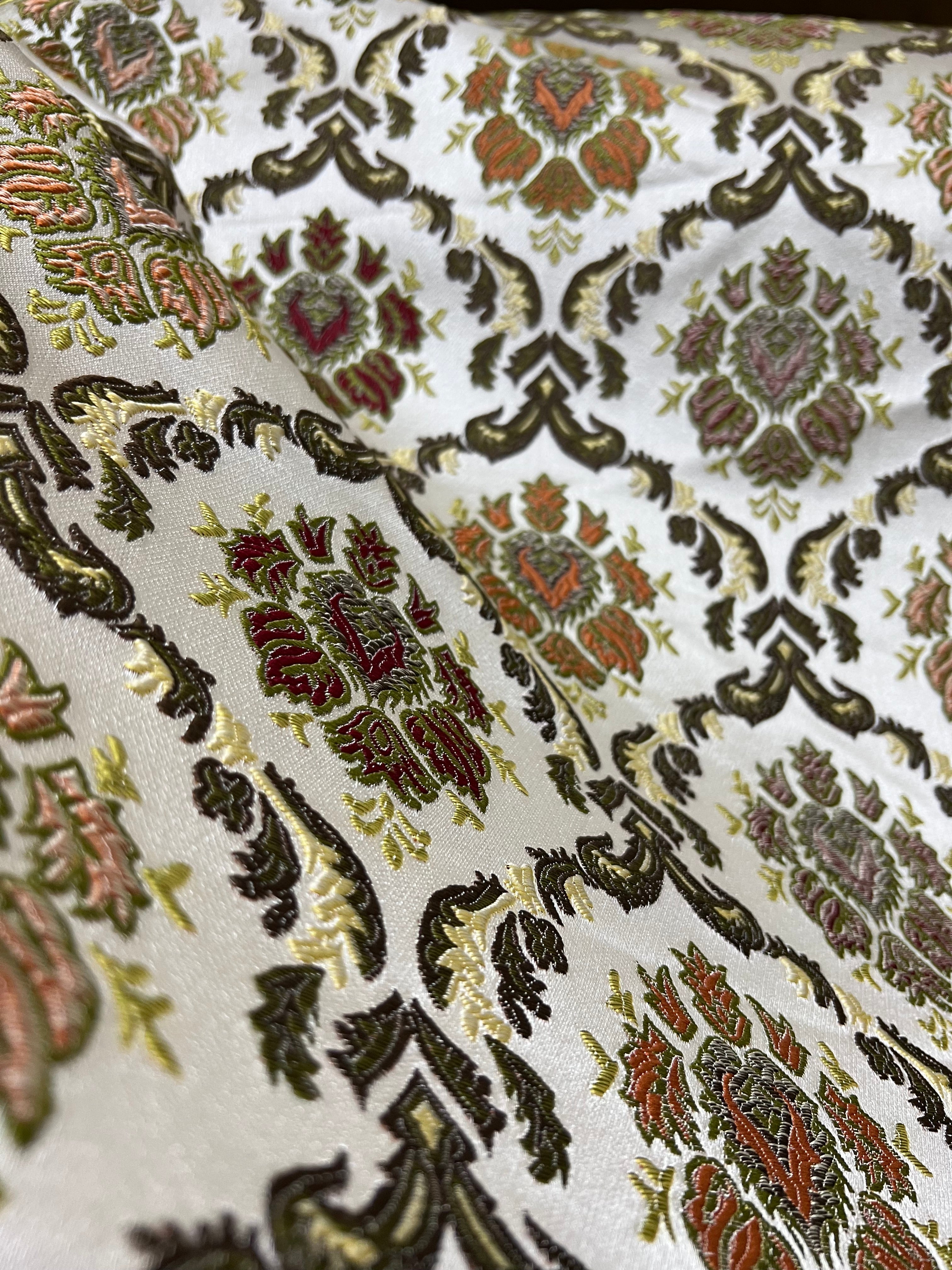 Decorative fabric with intricate Green floral pattern on a beige background